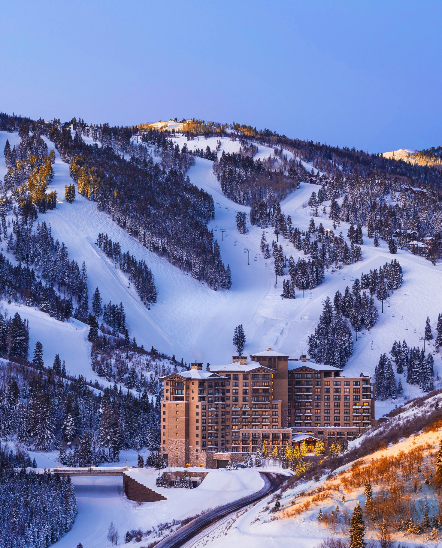 lodge next to snowy mountain with ski slopes