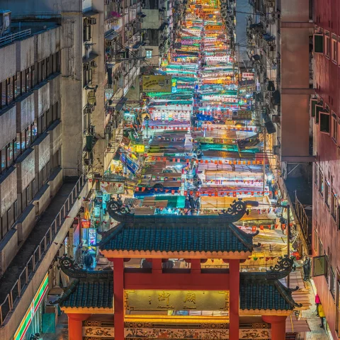a long street of bright lights in a city at a street market