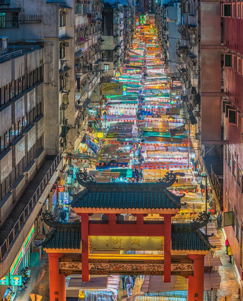 a long street of bright lights in a city at a street market