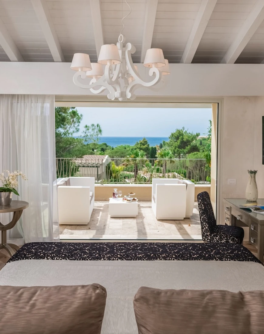 a living room with a white wooden chandelier overlooks the sea