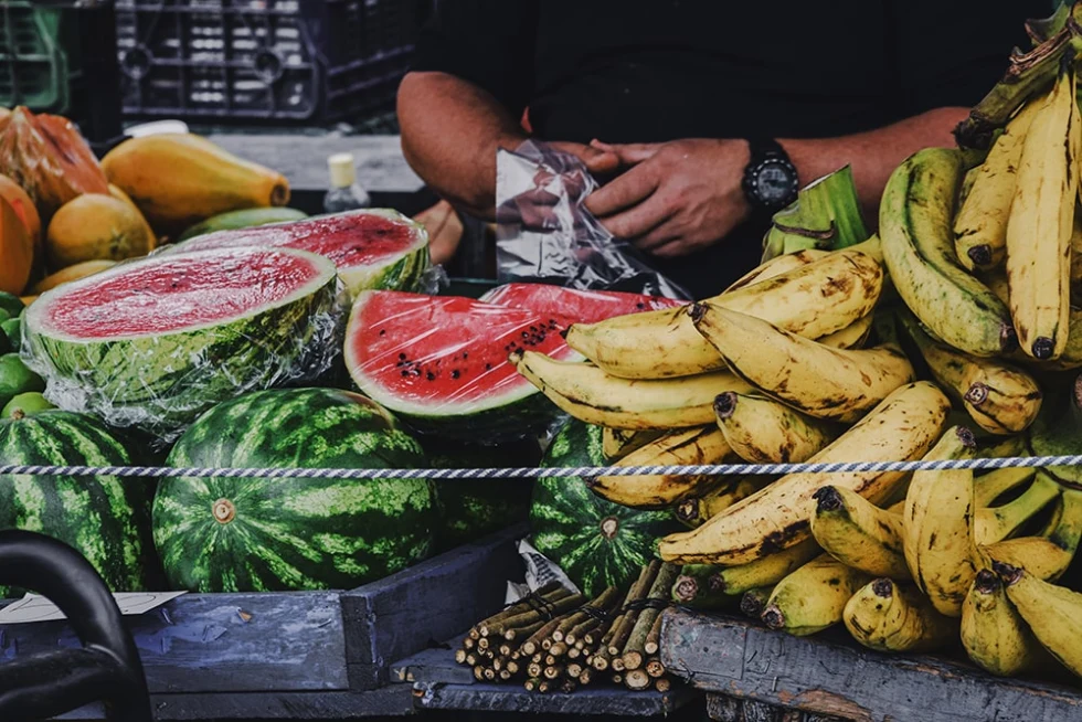 bananas and watermelon at a fruit stand during daytime