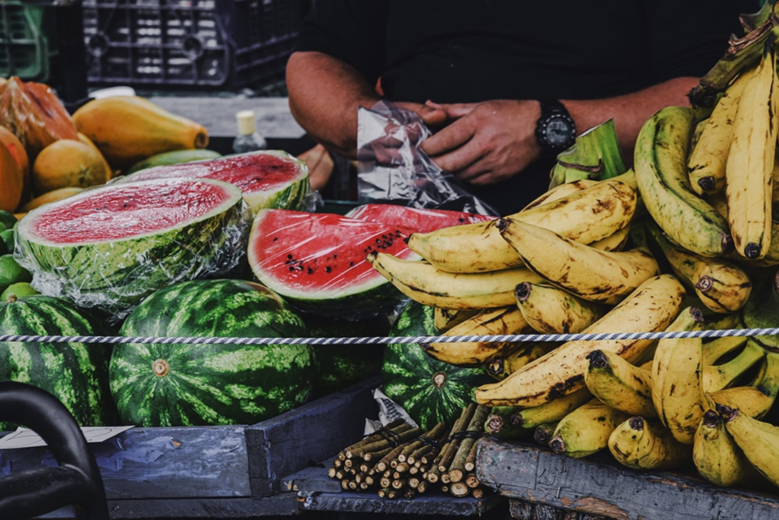 bananas and watermelon at a fruit stand during daytime