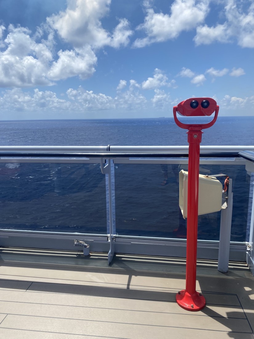 A binocular outlook over the blue sea from a cruise ship deck. 