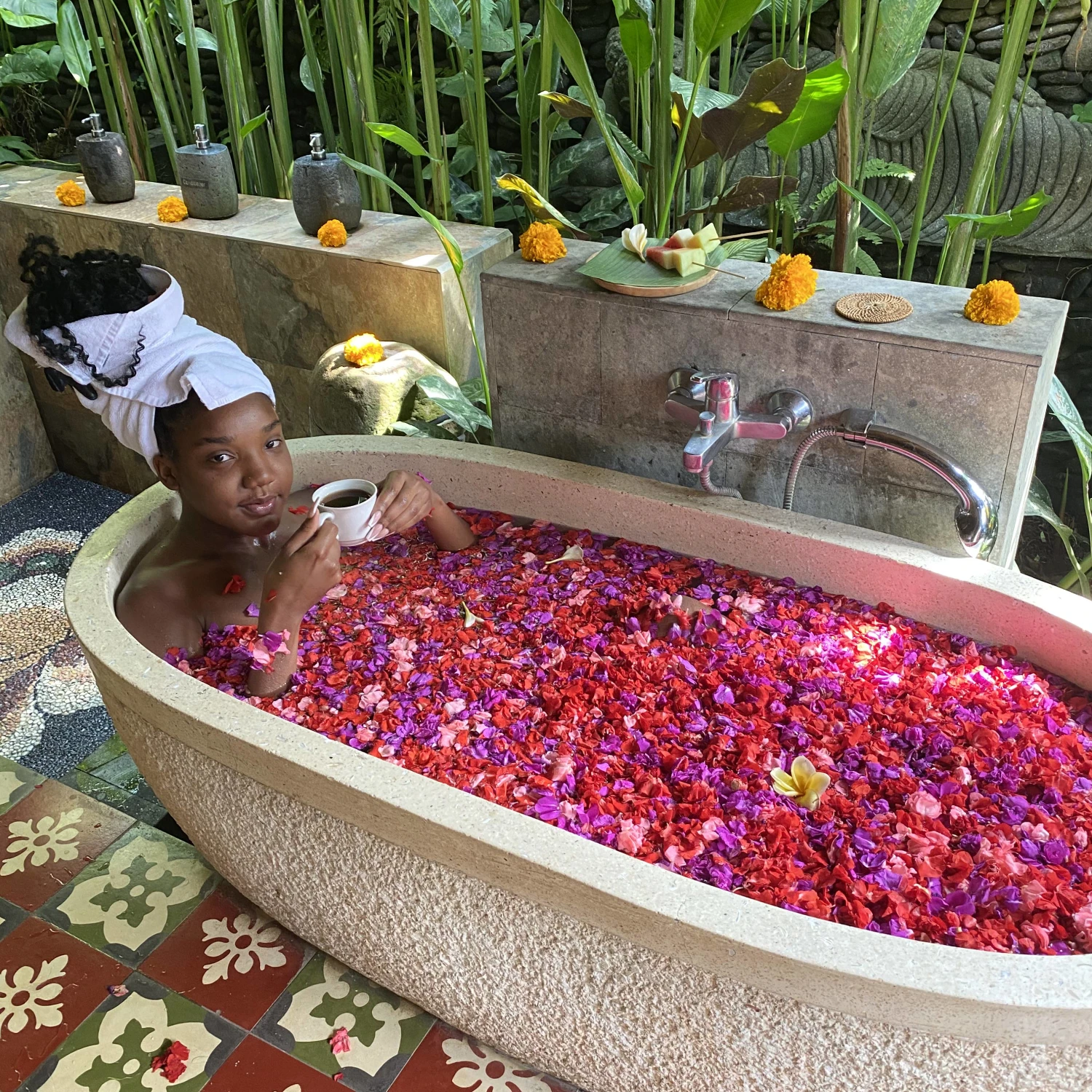 Anyah posing in a bath tub filled with water and rose petals