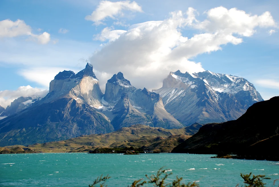 turquoise water under snow mountains