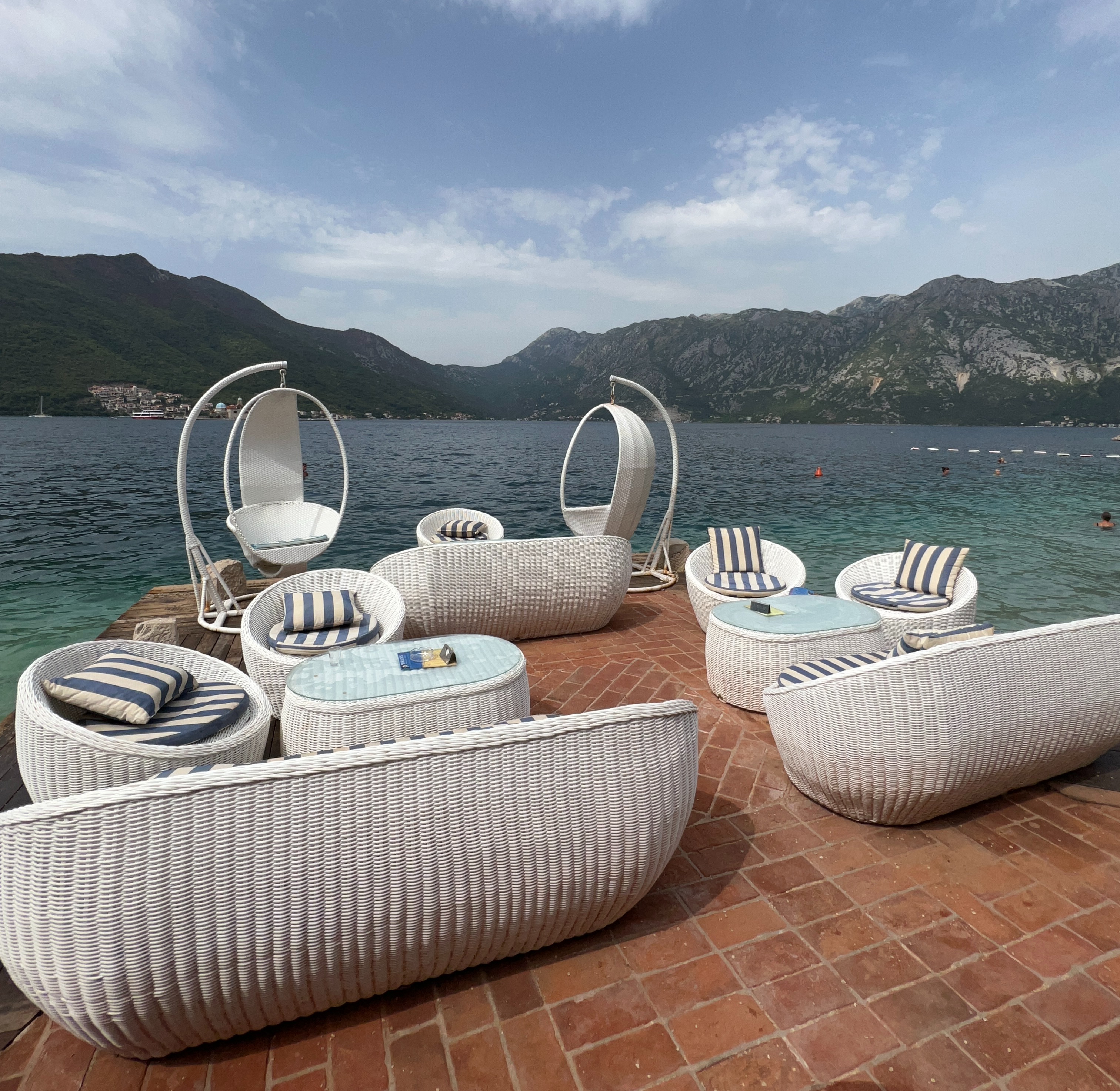 white lounge chairs on a deck overlooking ocean at a beach bar