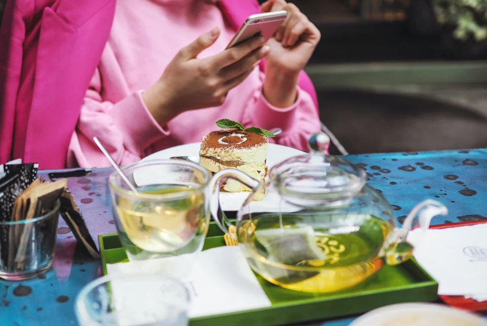 Girl in pink coat eating dessert in Milan.
