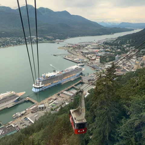 cable car above a city with a wide canal and mountain range