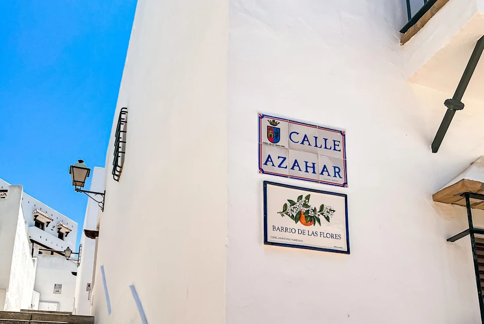 alley with stairs past a white building into the clear blue sky