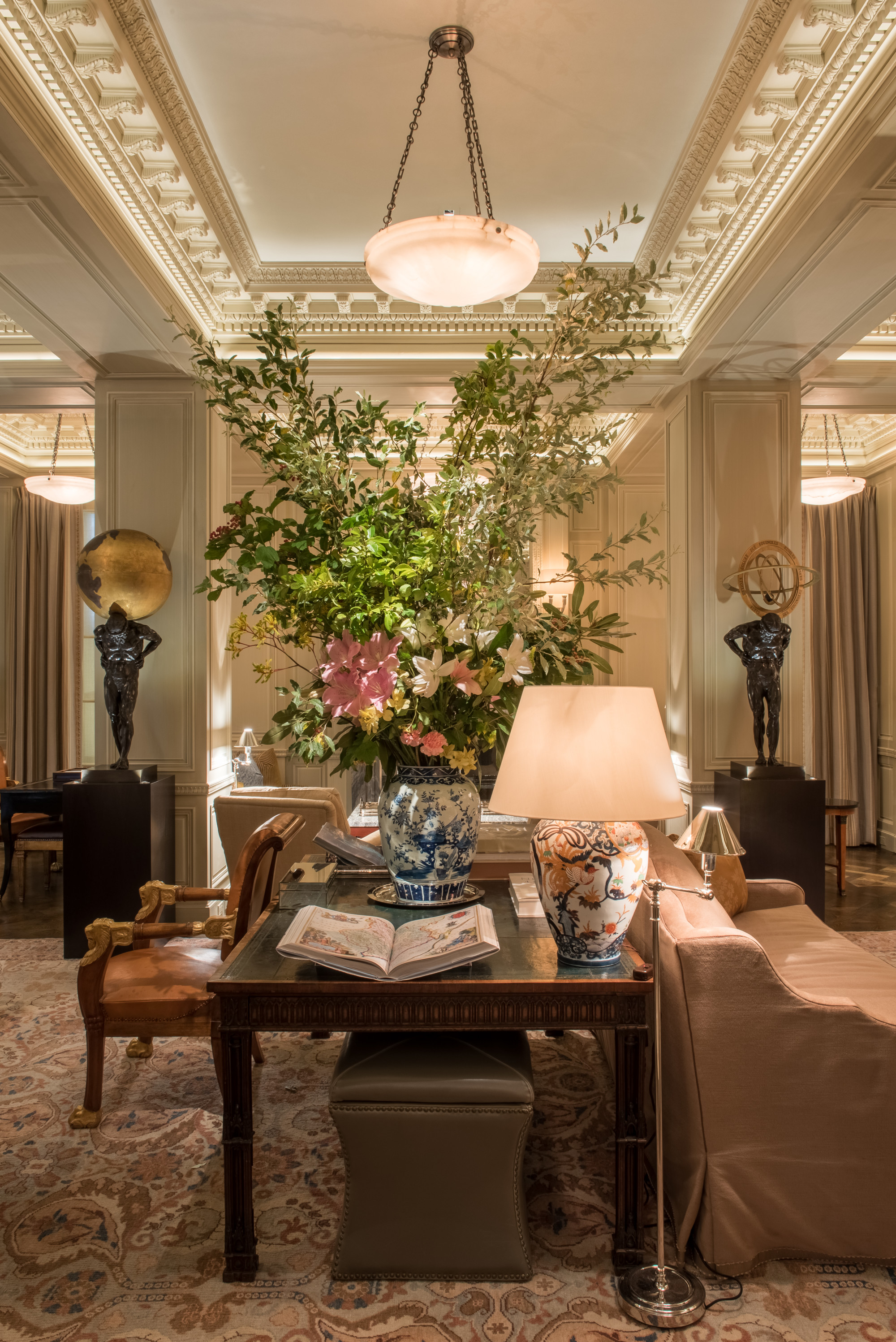 a white-and-blue vase holds a luxurious bouquet of flowers on a wooden table 