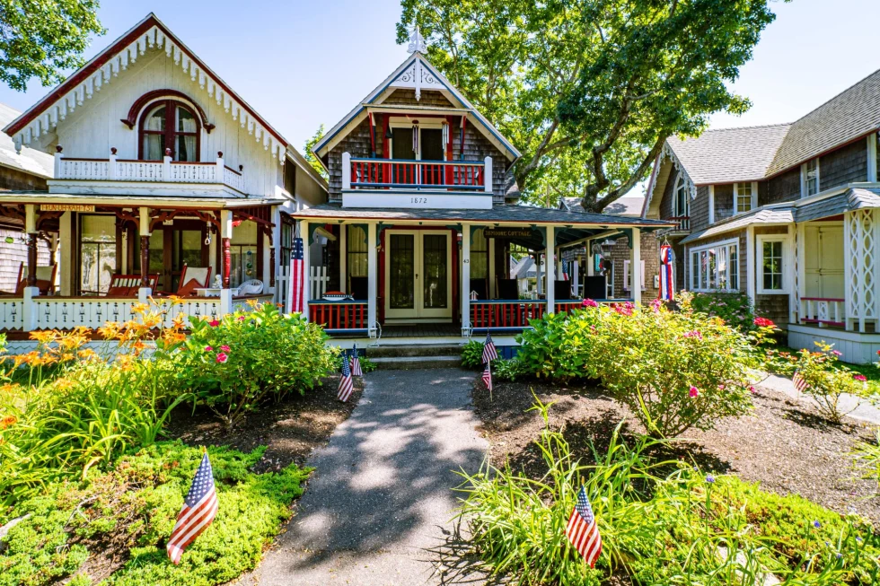 charming houses decorated like gingerbread houses in red white and blue colors with american flags in the front yard