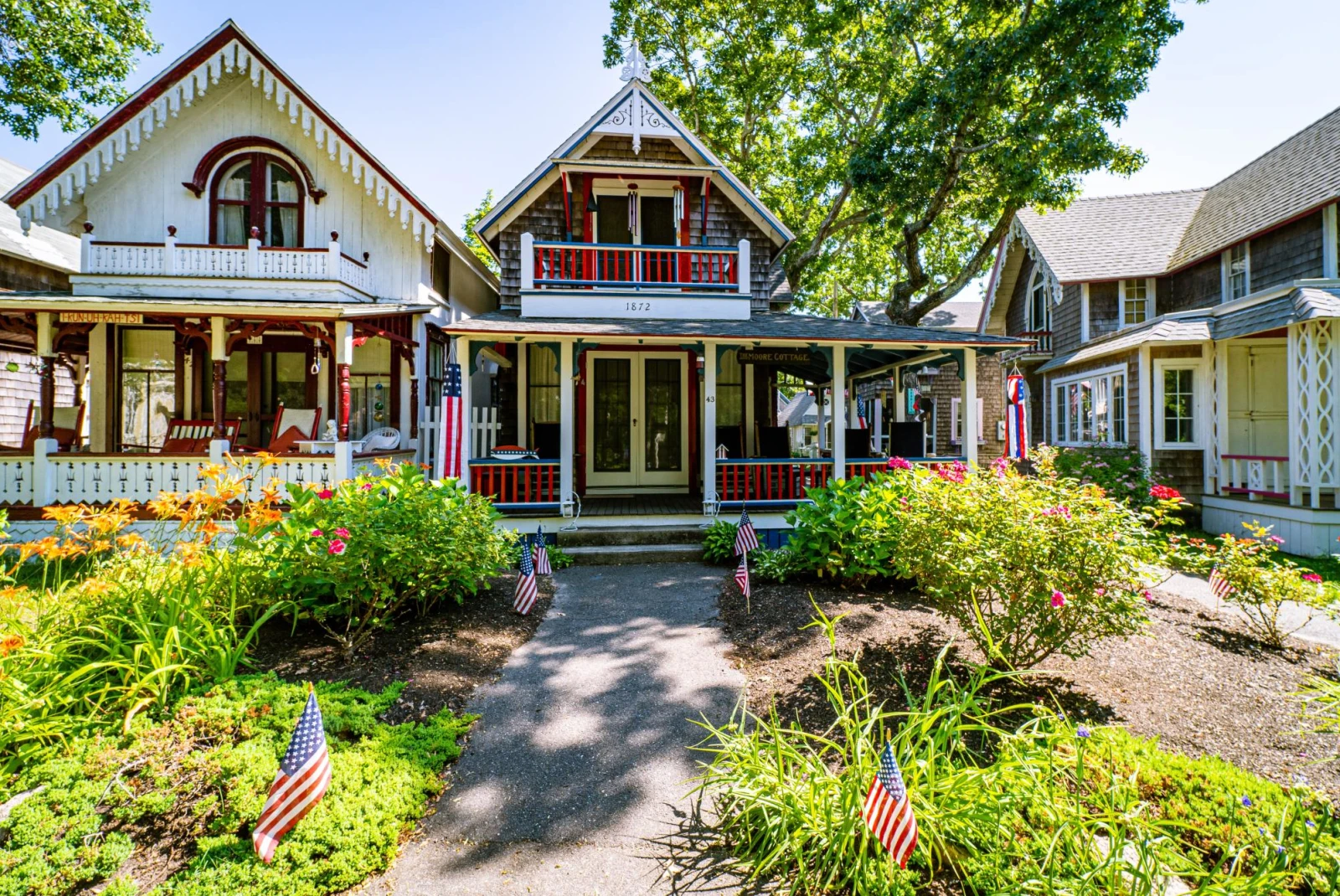 charming houses decorated like gingerbread houses in red white and blue colors with american flags in the front yard