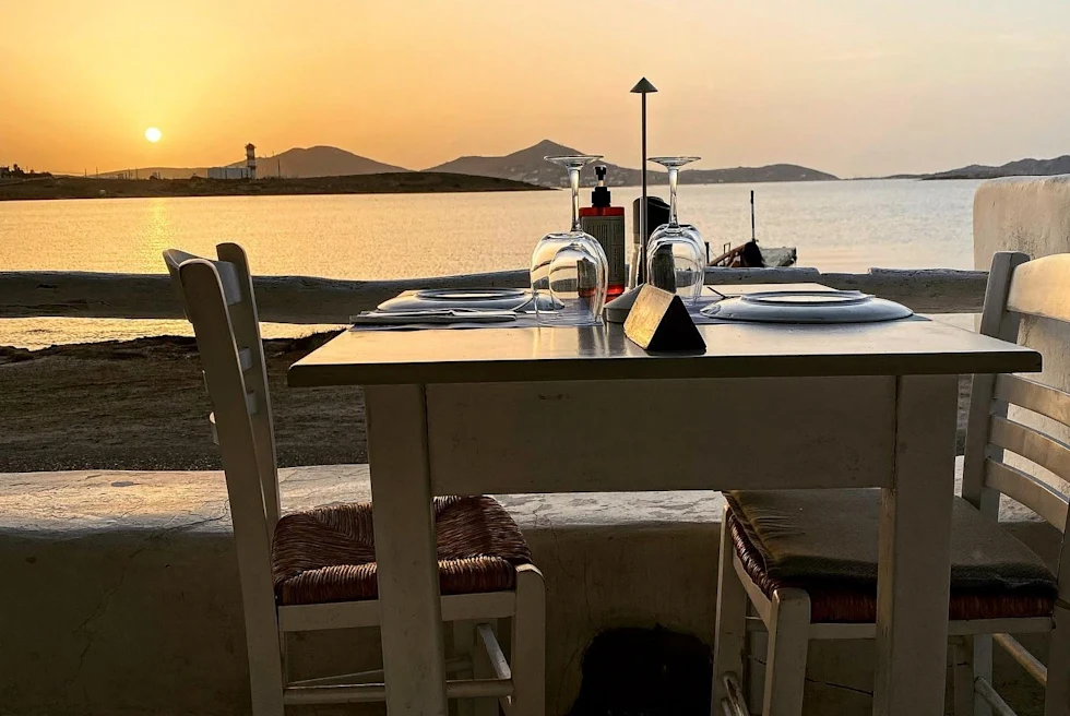 A romantic dining table set during sunset on the beach view.