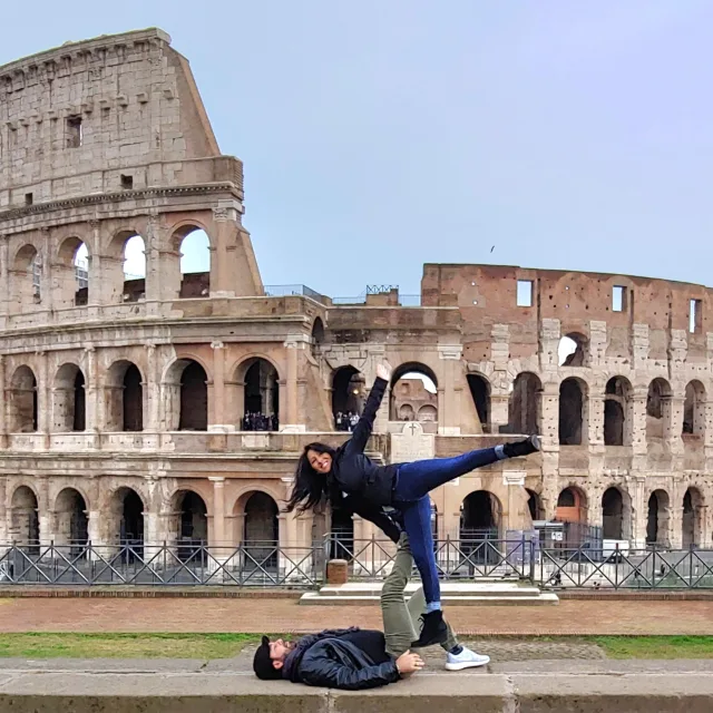 Jang and a person doing yoga poses in front of the colosseum in Rome, Italy