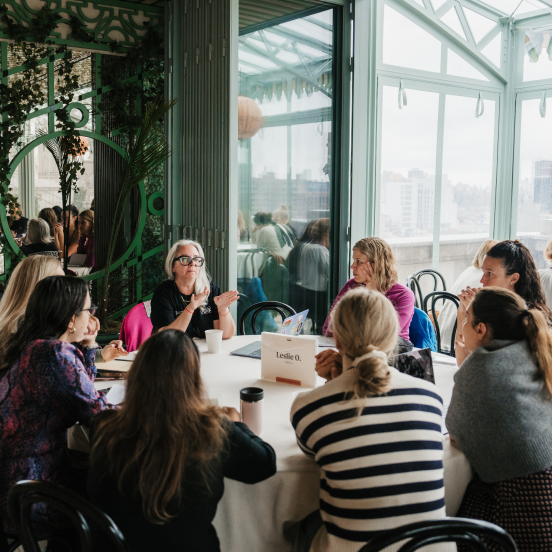 a group of people sit and chat around a table