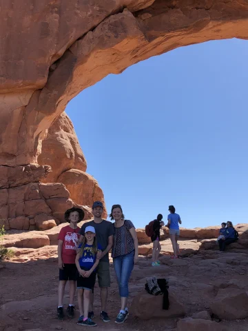 A family in a cave like structure on a rocky hill.
