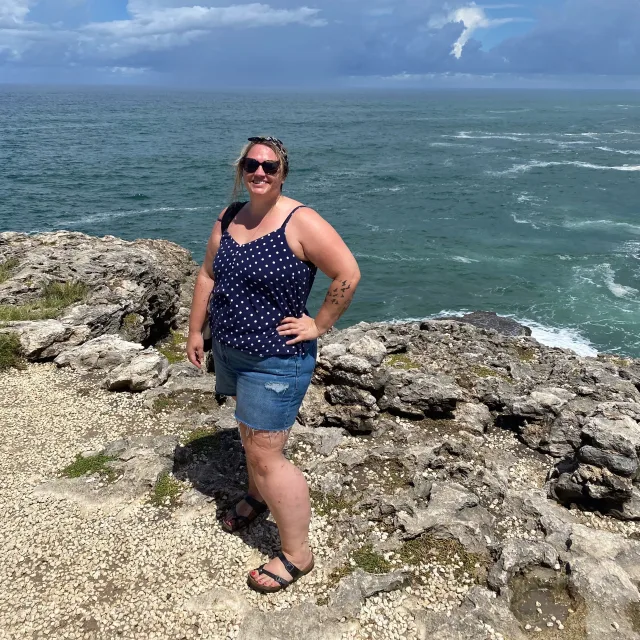 Travel advisor Laurel Hasbargen standing on a cliff overlooking the sea.