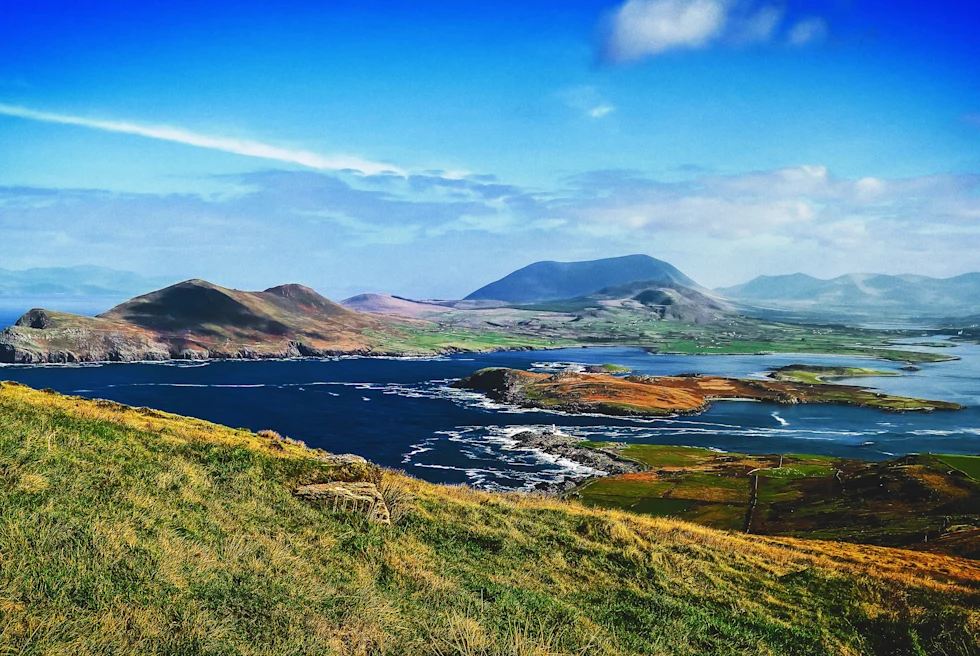 Panoramic views of hills in Ireland and water.