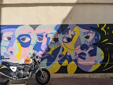 A motorcycle next to street art in Marseille. 