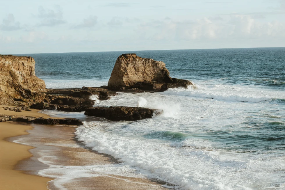 Brown rock formation on seashore.