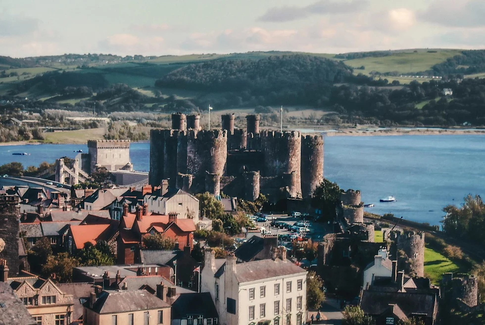 a small town on the water with a castle in the countryside