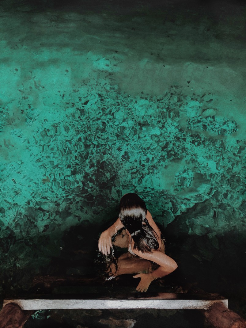 Woman standing over Cenote in Tulum, Mexico