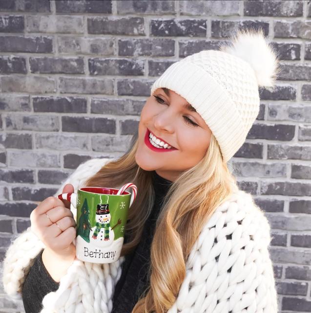 Girl in beanie with mug of hot chocolate
