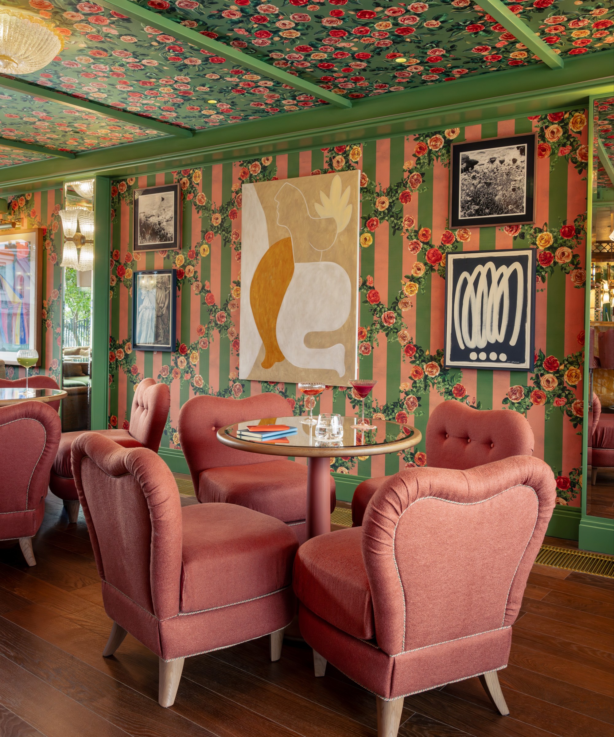 plush pink chairs surround a round table in a colorful dining room
