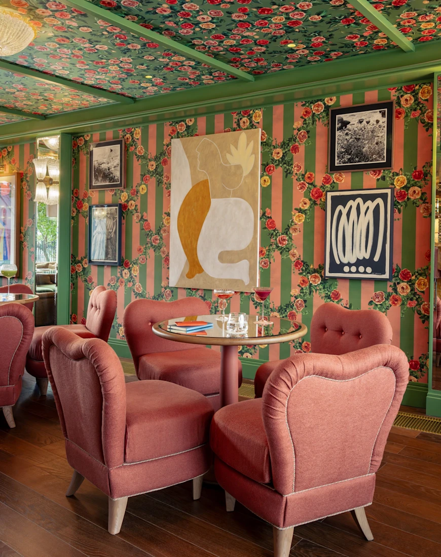 plush pink chairs surround a round table in a colorful dining room