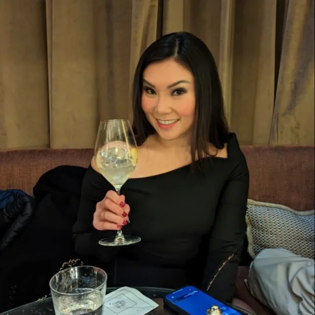 Travel advisor wearing a black outfit and holding a glass of drink
