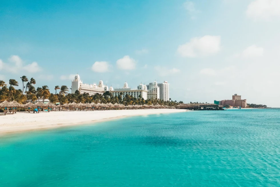 Beachfront resort next to powdery sand beach and turquoise waters in Aruba.