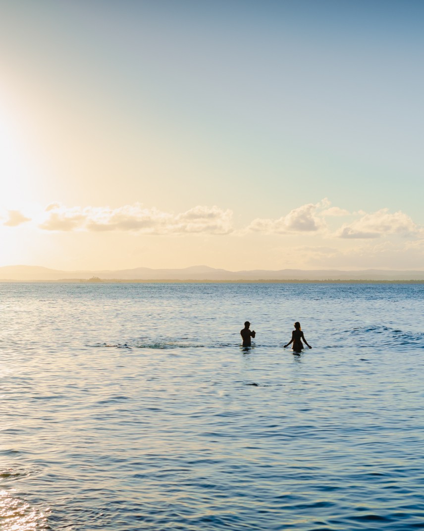Two people swimming in ocean during daytime