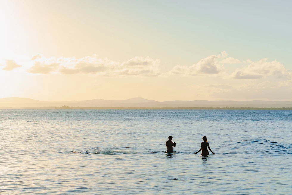 Two people swimming in ocean during daytime