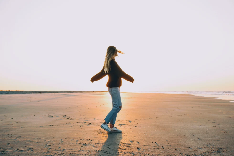 Woman standing on the beach during sunset
