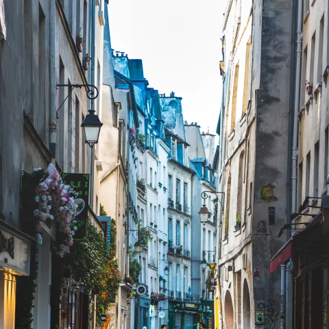 Two people walking down a street in Paris' Le Marais neighborhood. 