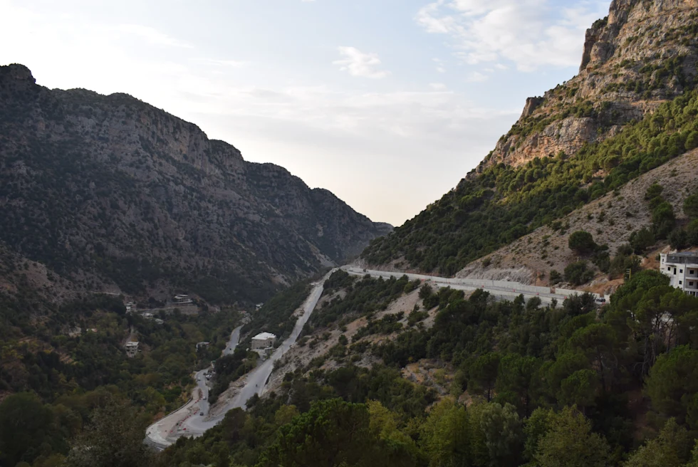 Road on the side of a mountain with clouds during daytime