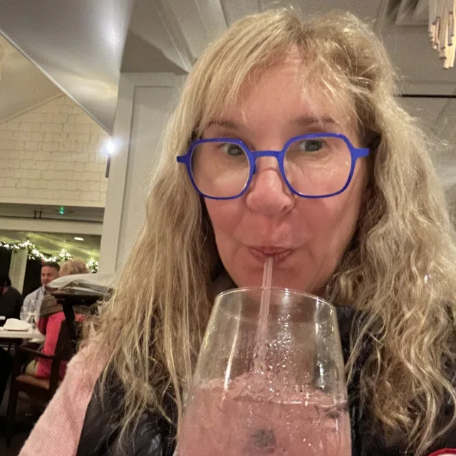 Travel Advisor Michele Buring sips on a pink cocktail with ice and a straw