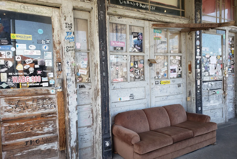 brown couch outside of a white building during daytime