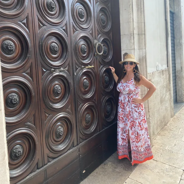 Travel advisor Heather Twesme posing next to a large, ornate door.