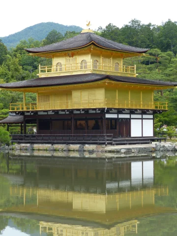 A yellow-painted pavilion in the water next to the shore