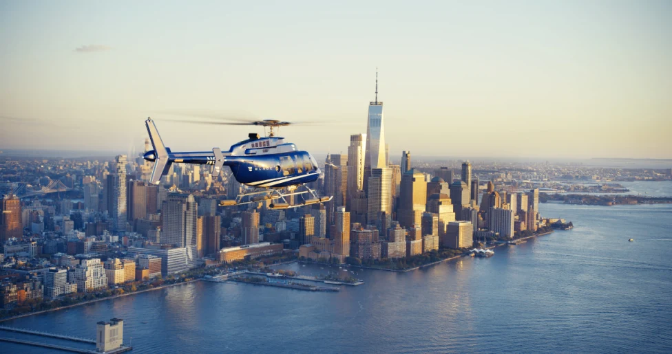 A BLADE helicopter flying over New York at sunset.