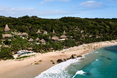 Bird's eye view of the thatched roof of Nihi Sumba Island, a luxury beachfront hotel in Indonesia