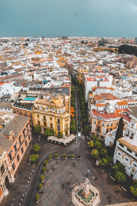 An aerial view of Madrid, Spain with colorful red and yellow buildings around an open square.