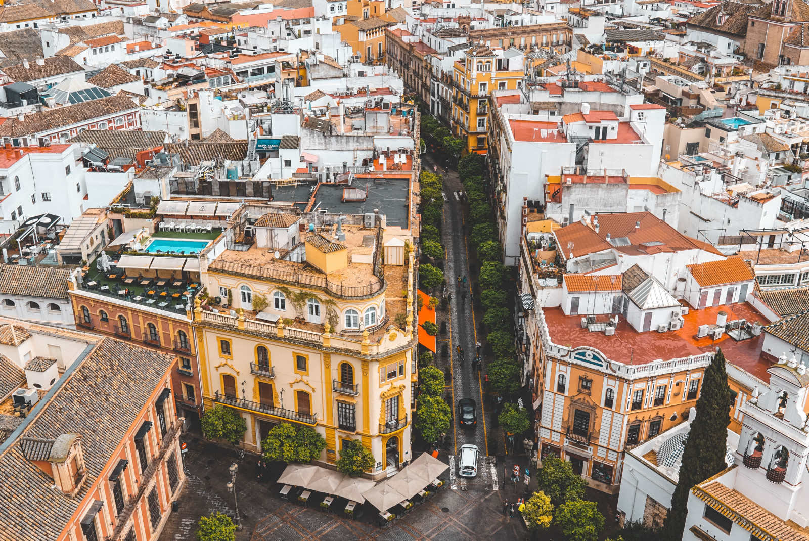 An aerial view of Madrid, Spain with colorful red and yellow buildings around an open square.