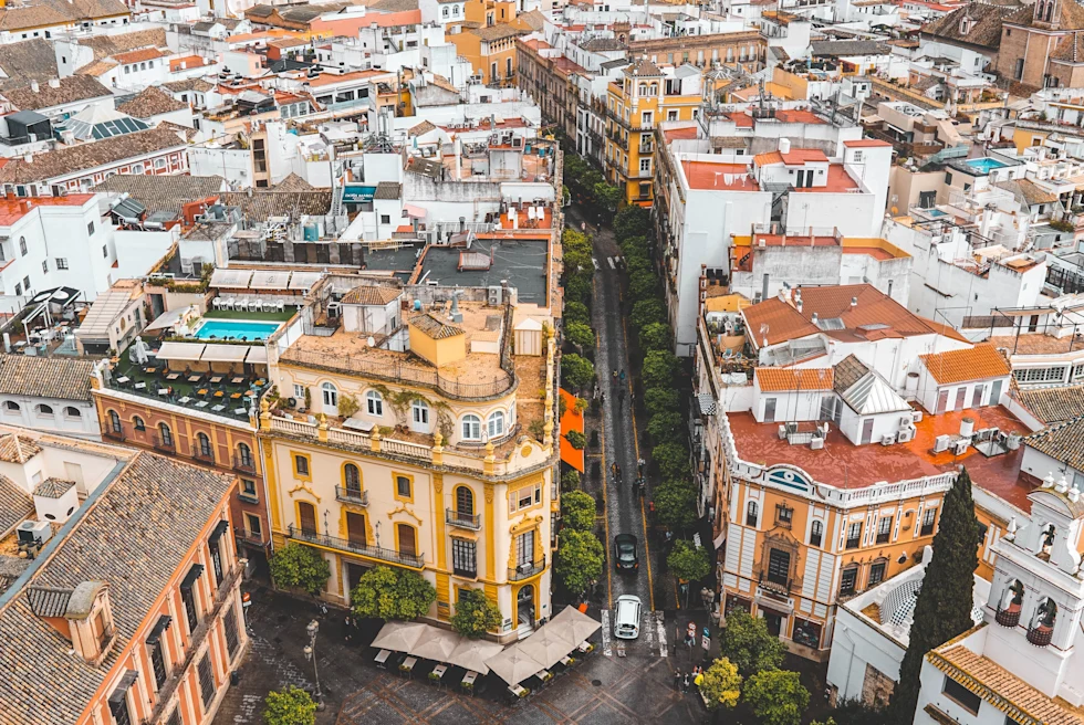 An aerial view of Madrid, Spain with colorful red and yellow buildings around an open square.