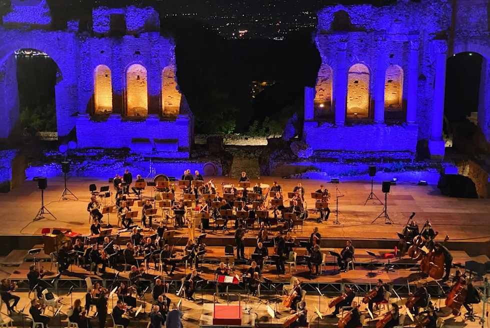 An orchestra playing in front of an audience.