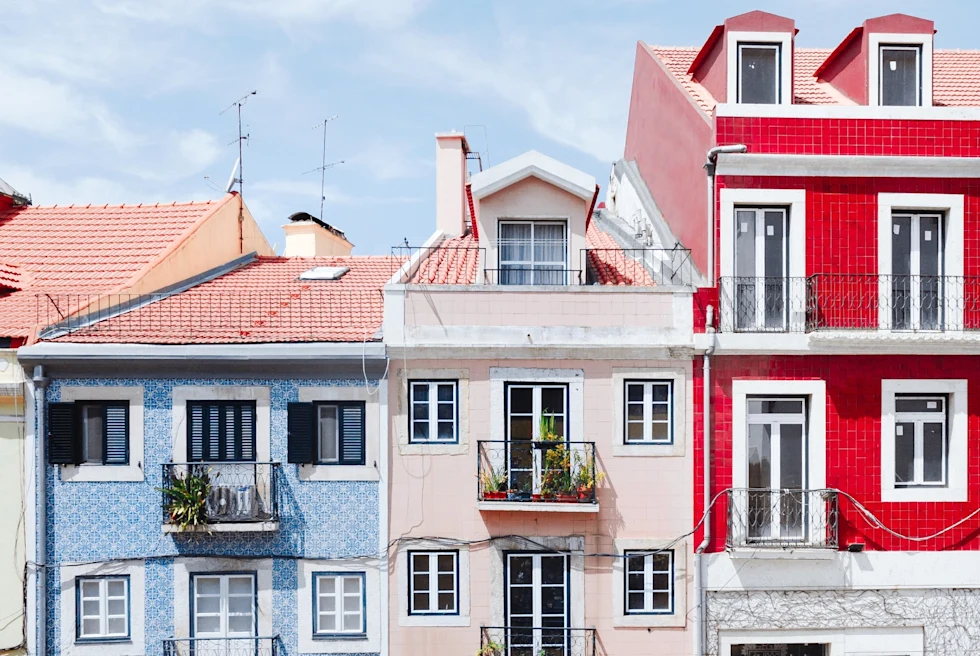 Light blue, pink and red buildings in a row.