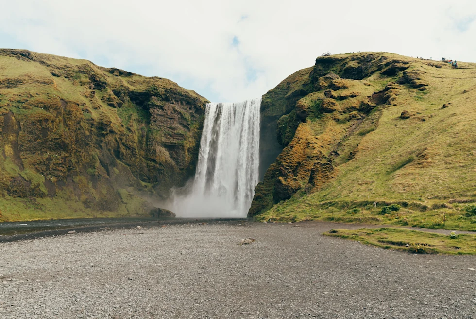 A waterfall out of green hills.