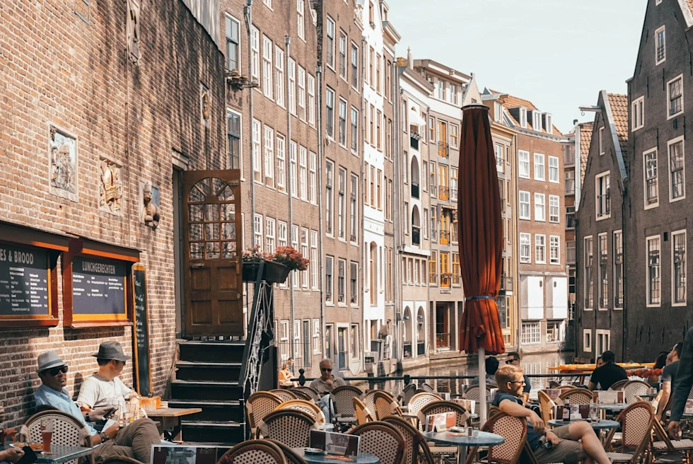 an outdoor restaurant in a canal during the day