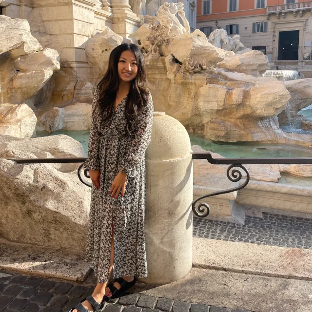 Travel Advisor Cindy Lu in a long dress in front of the Trevi Fountain.